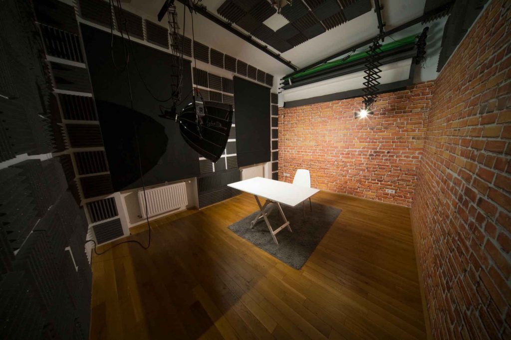 Foto- und Videostudio mit weißem Tisch, Sessel und Lampe