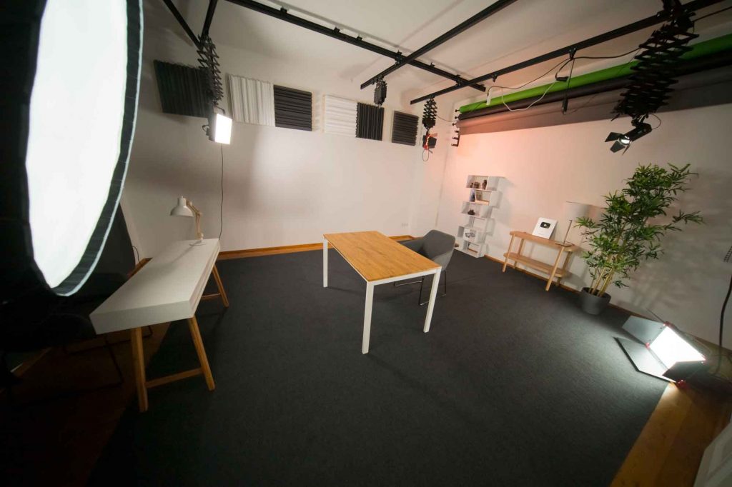 Foto- und Videostudio mit Lampen und Holztisch in der Mitte
